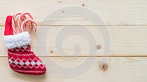 Christmas gift background with red baby stocking sock candy cane present on white pine wood background for X`mas winter holiday
