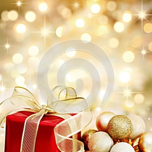 Christmas gift and baubles on golden background