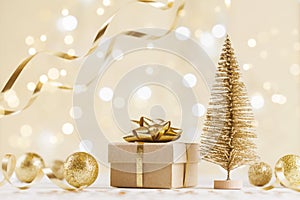 Christmas gift box against golden bokeh background. Holiday greeting card.