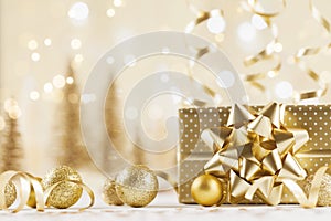 Christmas gift box against golden bokeh background. Holiday greeting card.