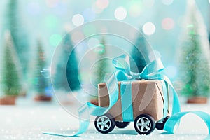 Christmas gift box against turquoise bokeh background. Holiday greeting card.