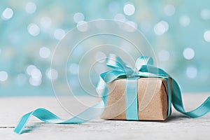 Christmas gift box against turquoise bokeh background. Holiday greeting card. photo