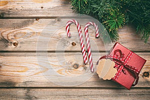 Christmas gift box with blank tag on wooden background, copy space, top view