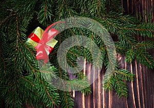 Christmas gift box. Christmas presents with red ribbon at dark wooden table with Christmas tree. Copy space.