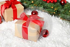 Christmas gift box and decor on table with artificial snow, closeup