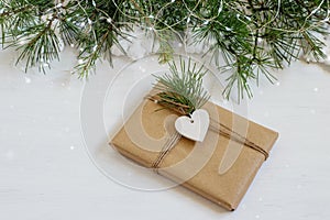Christmas gift box festively decorated on the white home table. Zero waste, eco friendly craft paper and handmade gift