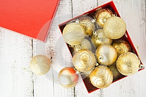 Christmas Gift Box with golden baubles and Decorations. White rustic wooden table