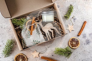 Christmas gift box with hugge items textile pouch, candle, wooden toy for tree. Care package concept photo