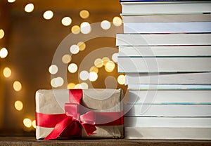 Christmas gift box and pile of books with fairy lights