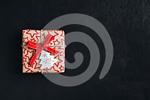 Christmas gift box with red bow ribbon on a dark concrete background