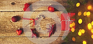 Christmas gift box and red decoration over wood background