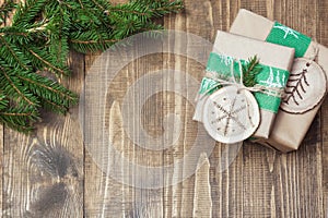 Christmas gift box in rustic style wrapped in paper with decor of wooden sliced with woodburning symbol.