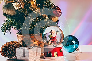 Christmas gift box and Santa Claus in snow globe close up