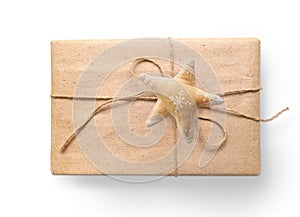 Christmas gift box wrapped in brown recycled paper and tied sack rope with a star top view isolated on white background