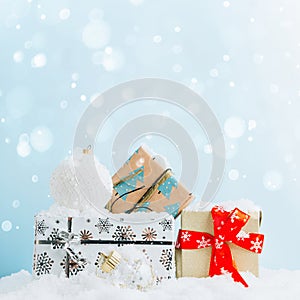 Christmas gift boxes against light blue bokeh background. Holiday greeting card with copy space.