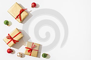 Christmas gift boxes background. New year Presents in golden wrapping paper with red ribbons and balls on white background.