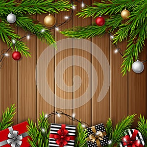 Christmas gift boxes with christmas balls and fir branches on bright wooden background