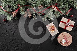 Christmas gift boxes on dark holiday background with Fir branches, pine cones, red decoration