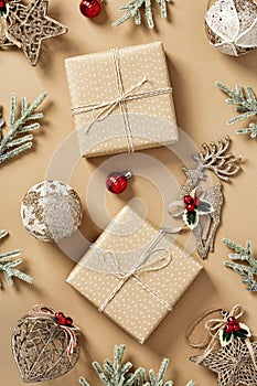 Christmas gift boxes with decorations and fir branches on beige background. Flat lay, top view. Merry Christmas and Happy New Year