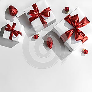 Christmas gift boxes with red ribbon and decoration on white background. Xmas and Happy New Year holiday, bokeh, light. Flat lay