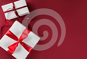 Christmas gift boxes with red ribbon on red paper background. Xmas and Happy New Year theme