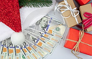 Christmas gift boxes and red Santa hat with american one hundred dollar bills