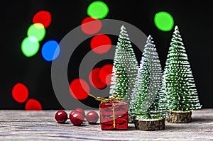 Christmas gift boxes under pine tree on wooden table over bokeh background