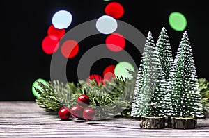 Christmas gift boxes under pine tree on wooden table over bokeh background