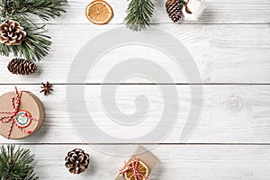 Christmas gift boxes on white wooden background with Fir branches, pine cones.