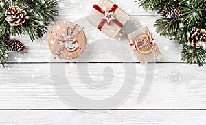 Christmas gift boxes on white wooden background with Fir branches, pine cones.