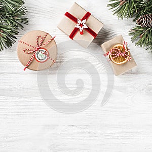 Christmas gift boxes on white wooden background with Fir branches, pine cones. Xmas and Happy New Year theme.
