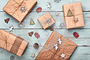 Christmas gift boxes wrapped in kraft paper on blue wooden table. Zero waste, eco friendly packaging