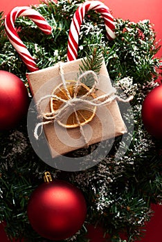 Christmas gift boxes wrapped kraft paper decorated ribbon bow and fir branches on marsala red background. Flat lay, top