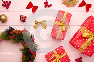 Christmas gift boxes with wreath and decorations on pink wooden background. Thanksgiving Day