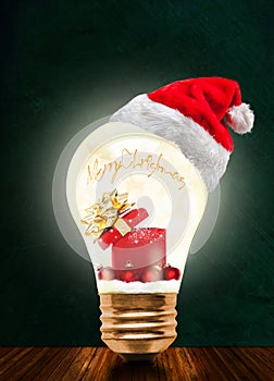 Christmas Gift in Glowing Light Bulb With Santa Hat And Copy Spa