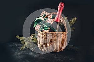 Christmas gift hamper with champagne and gift on black. Space for your greetings. greeting card