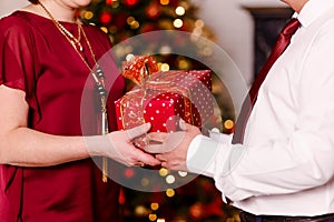 Christmas gift in the hands of a man and a woman close