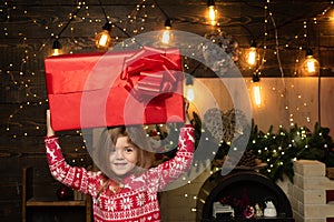 Christmas gift for kids - happiness concept. Happy Christmas little girl with a big Christmas present in her hands