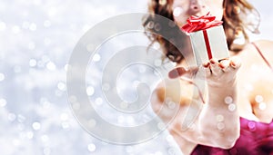 christmas gift present, woman with package on blurred bright lig