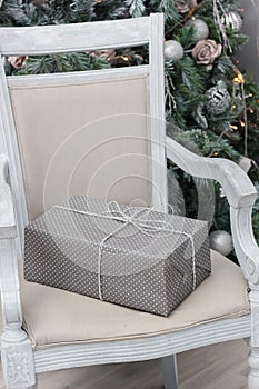 Christmas gift at silver box on the chair.