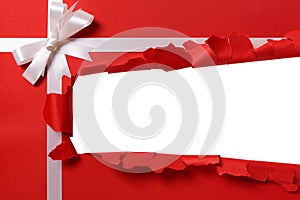 Christmas gift torn open strip, white ribbon bow, red wrapping paper