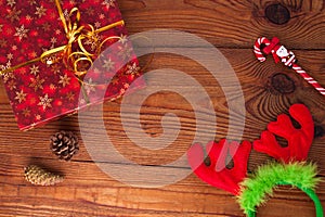 Christmas gift, trendy red present box wrapped with golden ribbon decoration on rustic wooden background. Flatlay style