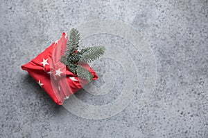 Christmas gift wrapped in red textile. Zero waste. Xmas. Furoshiki style. photo