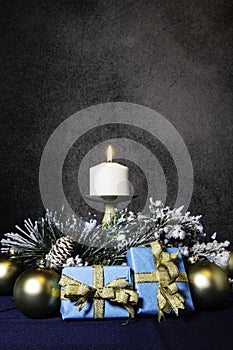 Christmas gifts in blue and gold with burning candle