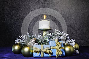 Christmas gifts in blue and gold with burning candle