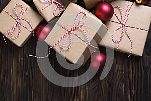 Christmas gifts box presents with red balls on wooden background top view text space
