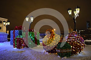 Christmas gifts and Christmas decorations on the background of street lamps and the night sky