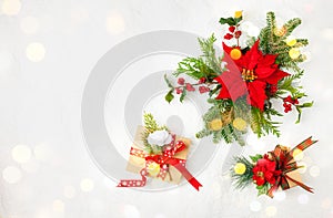 Christmas gifts, decorations and poinsettia flowers on white background. Creative winter holiday concept. Flat lay