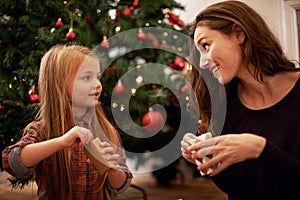 Christmas gifts, family and mother with girl, having fun or bonding in home. Love, care and happy mom with child opening