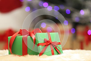 Christmas gifts on fuzzy rug against blurred background